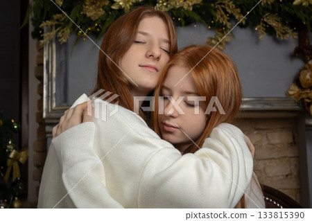 Two young women with long red hair wearing white Christmas sweaters 133815390