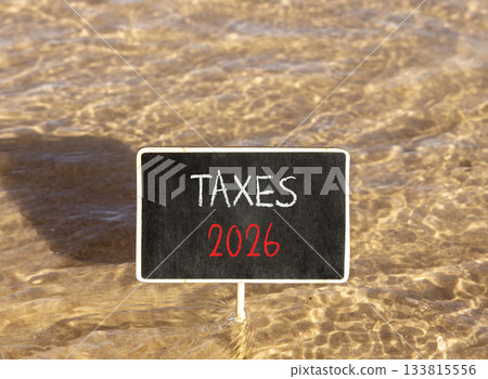 Taxes 2026 new year symbol. Concept words Taxes 2026 on beautiful black blackboard. Beautiful Red sea water background. Business and taxes 2026 new year concept. Copy space. 133815556