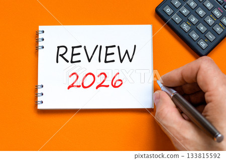 Review 2026 symbol. Concept words Review 2026 on beautiful white note. Black calculator. Beautiful orange paper background. Businessman's hand. Business and review 2026 concept. Copy space. Review 2026 symbol. Concept words Review 2026 on beautiful white note. Black calculator. Beautiful orange paper background. Businessman's hand. Business and review 2026 concept. Copy space. 133815592