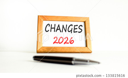 Changes 2026 symbol. Concept words Changes 2026 on beautiful wooden picture frame. Beautiful white paper background. Beautiful black pen. Business and changes 2026 concept. Copy space. 133815616