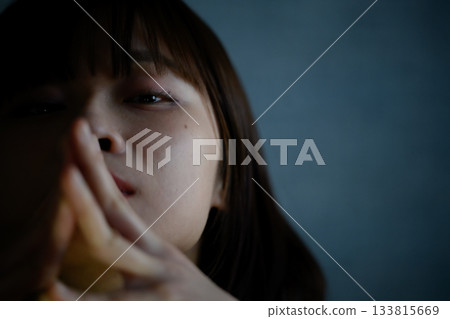黑暗中一位年輕女子雙手緊握的肖像 133815669