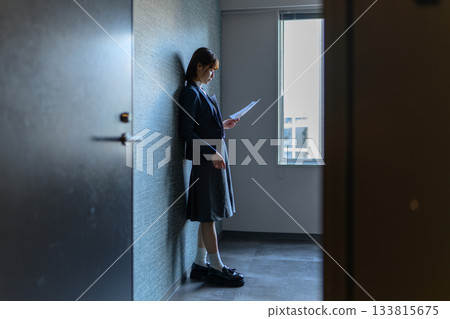 Female students reading documents in the hallway 133815675