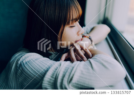 A young woman taking a nap by the train window A young woman taking a nap by the train window 133815707