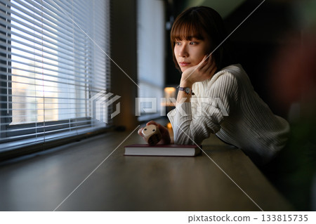 一位年輕的日本女子在窗邊沉思。 133815735