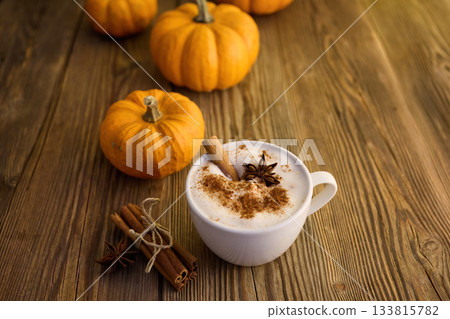 Autumn Pumpkin Spice Latte. A cozy autumn scene with a spiced latte, pumpkins, and cinnamon sticks Autumn Pumpkin Spice Latte. A cozy autumn scene with a spiced latte, pumpkins, and cinnamon sticks 133815782