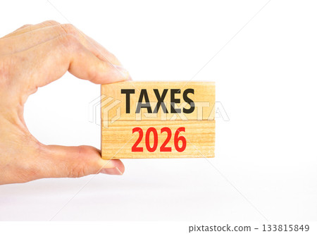 Taxes 2026 new year symbol. Concept words Taxes 2026 on beautiful wooden blocks. Beautiful white paper background. Businessman's hand. Business and taxes 2026 new year concept. Copy space. 133815849