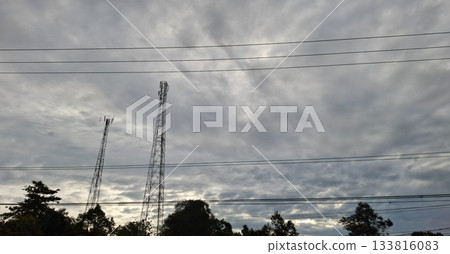 Telecommunication Towers Silhouette Against Overcast Sky 133816083
