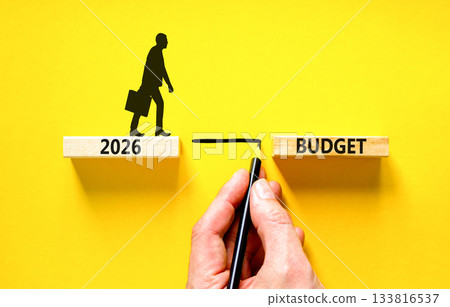 2026 Budget symbol. Concept words 2026 Budget on beautiful wooden blocks. Beautiful yellow background. Businessman holds pencil. Businessman icon. Business and 2026 budget concept. Copy space. 133816537