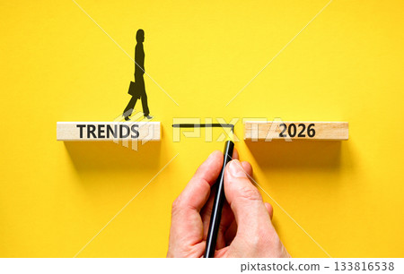 Trends 2026 symbol. Concept words Trends 2026 on beautiful wooden blocks. Beautiful yellow background. Businessman holds pencil. Businesswoman icon. Business Trends 2026 new year concept. Copy space. 133816538