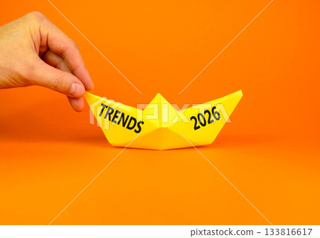 Trends 2026 new year symbol. Concept words Trends 2026 on beautiful yellow paper boat. Beautiful orange paper background. Businessman's hand. Business and Trends 2026 new year concept. Copy space. Trends 2026 new year symbol. Concept words Trends 2026 on beautiful yellow paper boat. Beautiful orange paper background. Businessman's hand. Business and Trends 2026 new year concept. Copy space. 133816617