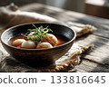 Warm bowl of tteokguk with sliced rice cakes and garnish, Korean New Year table 133816645