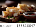 Slices of steamed turnip cake on a wooden board, soy dipping sauce nearby, simple Cantonese New Year atmosphere 133816647