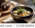 Warm bowl of tteokguk with sliced rice cakes and garnish, Korean New Year table 133816664