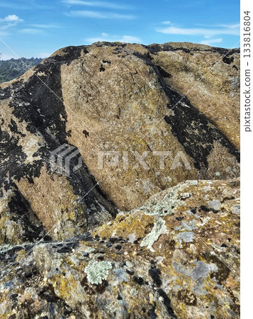 Rugged, Textured Mountain Slope under a Bright Sky Rugged, Textured Mountain Slope under a Bright Sky 133816804