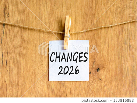 Changes 2026 symbol. Concept words Changes 2026 on beautiful white paper on wooden clothespin. Beautiful wooden background. Business and changes 2026 concept. Copy space. 133816898