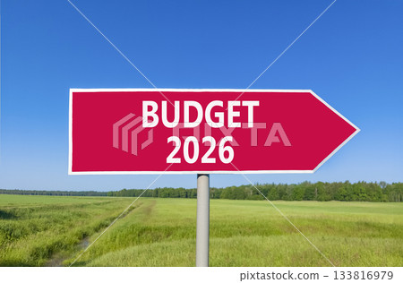 Budget 2026 symbol. Concept words Budget 2026 on beautiful red road sign. Beautiful green grass field forest and blue sky background. Business and budget 2026 concept. Copy space. Budget 2026 symbol. Concept words Budget 2026 on beautiful red road sign. Beautiful green grass field forest and blue sky background. Business and budget 2026 concept. Copy space. 133816979