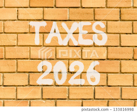 Taxes 2026 new year symbol. Concept words Taxes 2026 on beautiful old brown brick wall. Beautiful old brown brick wall background. Business and taxes 2026 new year concept. Copy space. Taxes 2026 new year symbol. Concept words Taxes 2026 on beautiful old brown brick wall. Beautiful old brown brick wall background. Business and taxes 2026 new year concept. Copy space. 133816998