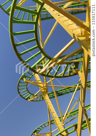 Green and yellow carousel tracks against a blue sky 133817111