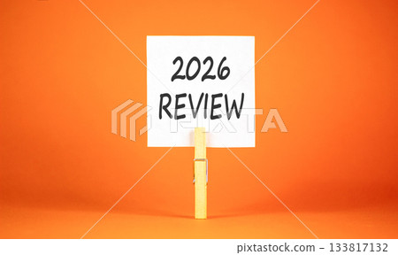 2026 Review symbol. Concept words 2026 Review on beautiful white paper on wooden clothespin. Beautiful orange background. Business and 2026 review concept. Copy space. 133817132