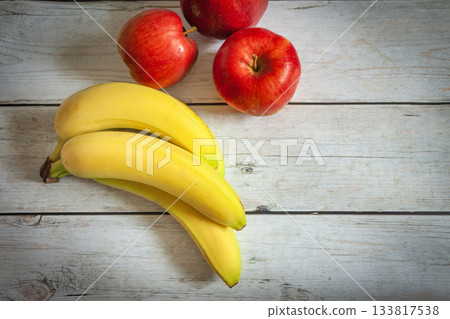 Apples and bananas on a wooden table 133817538