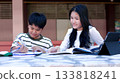 Asian Students Studying Together Outdoors with Books and Tablet 133818241
