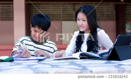 Asian Students Studying Together Outdoors with Books and Tablet Asian Students Studying Together Outdoors with Books and Tablet 133818241