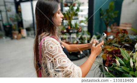 A Woman Enjoying Shopping for Beautiful Plants at a Colorful Garden Center Today 133818400