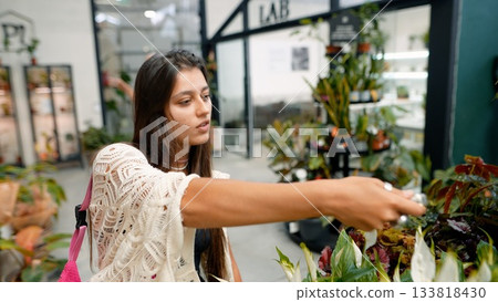 A Young Woman Happily Choosing and Selecting Various Plants in a Modern Greenhouse Environment A Young Woman Happily Choosing and Selecting Various Plants in a Modern Greenhouse Environment 133818430