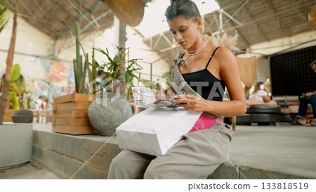 A Young Woman Engaging in Creative Work While Surrounded by Vibrant Trendy Space 133818519