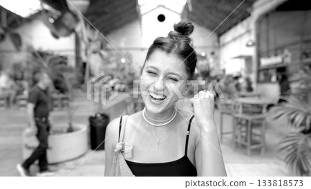 A Joyful Woman is Smiling Brightly while Enjoying a Lively Indoor Environment Filled with Energy 133818573