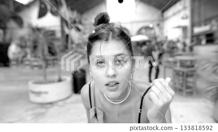 A Candid Portrait Featuring a Young Woman in an Exciting and Vibrant Market Setting 133818592