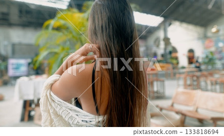 A thoughtful woman with long hair embodies modern beauty and elegance in an urban setting 133818694