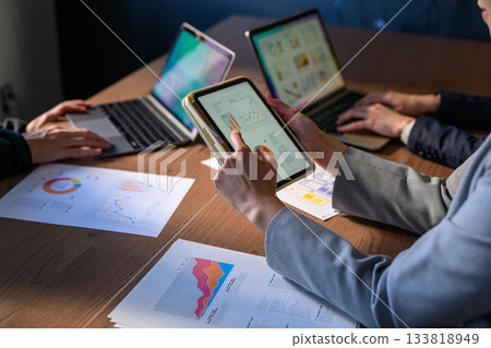 Business people using tablets and laptops in a conference room Business people using tablets and laptops in a conference room 133818949