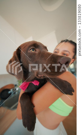 A Joyful and Playful Interaction Between a Happy Woman and Her Adorable Brown Dog 133819080