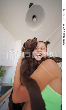 A Joyful and Happy Embrace with a Playful Chocolate Labrador in a Bright, Cheerful Kitchen A Joyful and Happy Embrace with a Playful Chocolate Labrador in a Bright, Cheerful Kitchen 133819108