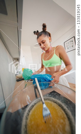 A Candid Cooking Moment in a Modern, Stylish Kitchen Filled with Culinary Creativity and Passion 133819145