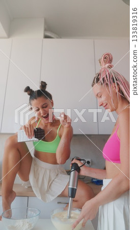 Enjoying exciting and funfilled cooking moments with friends together in the kitchen space 133819316