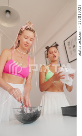 Two Women Cooking Together in a Bright and Inviting Kitchen Space Full of Life and Colors 133819322