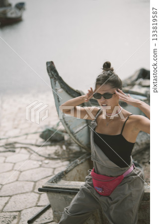 A Stylish Young Woman Posing by the Water in a Trendy and Fashionable Outfit of Choice 133819587