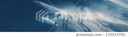 Freeride skiing. Two skiers descending a snowy mountain, kicking up powder snow and leaving tracks 133819703