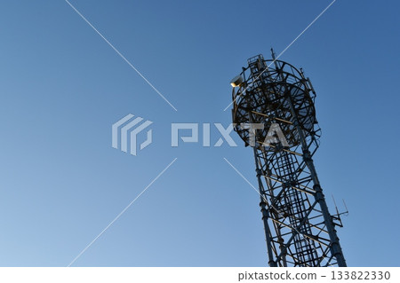 A base station tower shining against the blue sky A base station tower shining against the blue sky 133822330