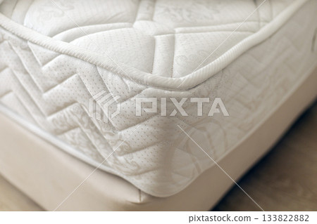 This bedding features a plush mattress with intricate quilting and a soft surface, ideal for ensuring comfort during sleep. Perfect for a cozy bedroom setting 133822882