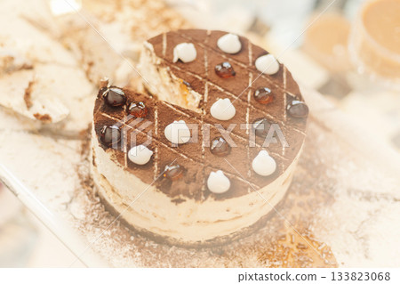 Delicious chocolate cake is beautifully arranged on a display stand, featuring creamy frosting and glossy jelly toppings. This treat is perfect for any celebration or dessert indulgence Delicious chocolate cake is beautifully arranged on a display stand, featuring creamy frosting and glossy jelly toppings. This treat is perfect for any celebration or dessert indulgence 133823068