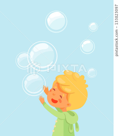 Boy playing with soap bubbles. Happy blonde kid in green coat reaching up on blue background with floating translucent spheres. Joyful childhood moment in soft cartoon vector illustration 133823097