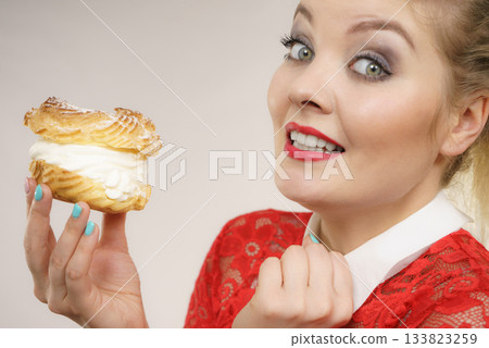 Funny woman holds cream puff cake Funny woman holds cream puff cake 133823259