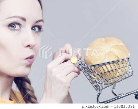 Woman holding shopping cart with bread 133823351