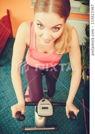 Woman working out on exercise bike. Fitness. 133823367