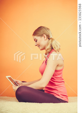 Fitness woman girl with tablet browsing internet. 133823368