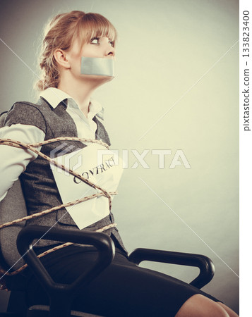 Woman bound by contract terms with taped mouth. 133823400