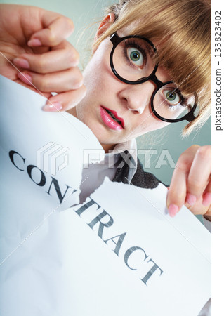 unhappy business woman showing crumpled contract unhappy business woman showing crumpled contract 133823402